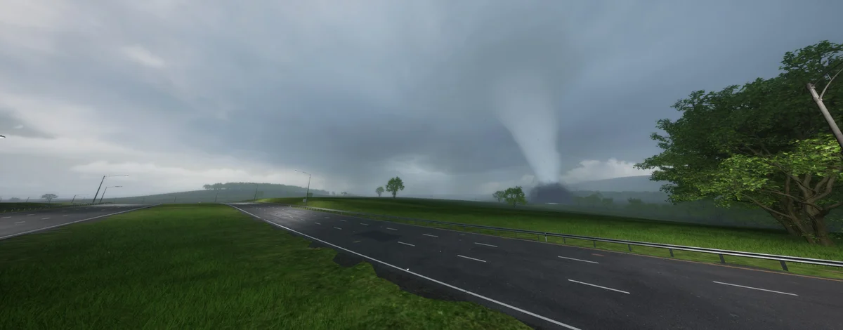 A rain-slicked divided highway running out across green farmland toward a large tornado touching down under a low storm deck