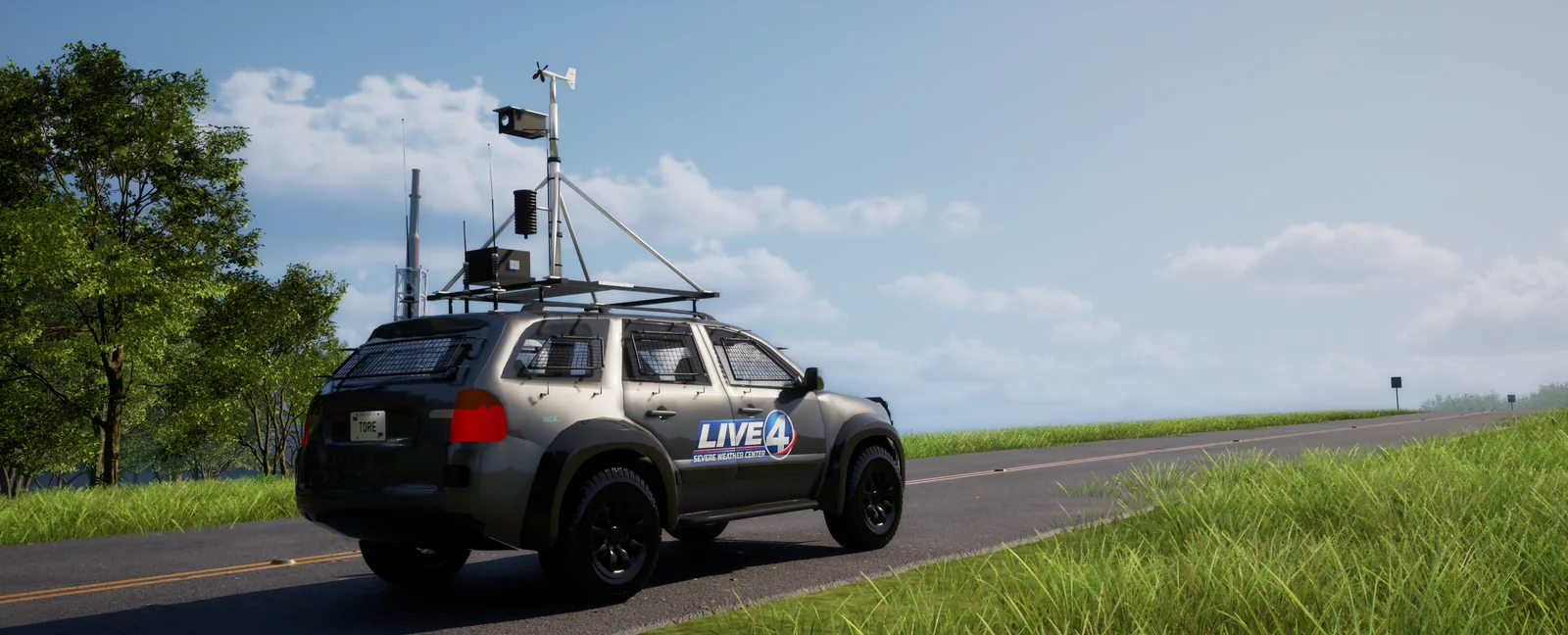 A liveried SUV with roof-mounted radar and weather instruments, parked on a road through open field