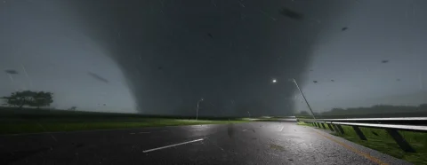 A tornado filling the sky at night, lit by a leaning streetlight, debris blowing across a wet road
